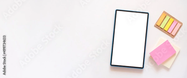 Fototapeta Banner with tablet with copy space, mockup on light beige background. Colorful stationery, stickers on the side. Minimalism, flat lay, top view.