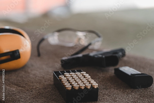 Obraz The sniper is preparing to hit the target. Guns and shooting equipment in the shooting range