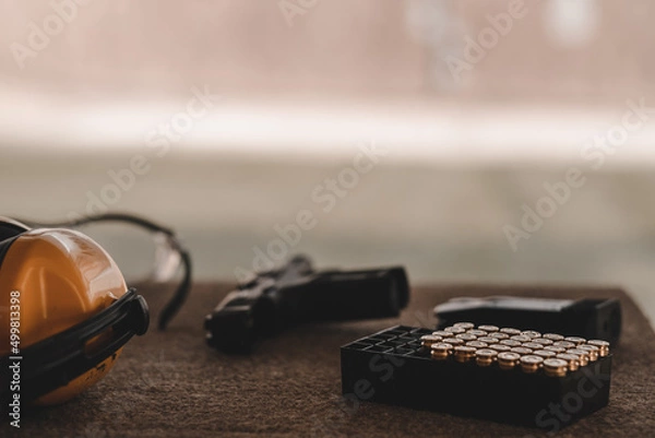 Obraz The sniper is preparing to hit the target. Guns and shooting equipment in the shooting range