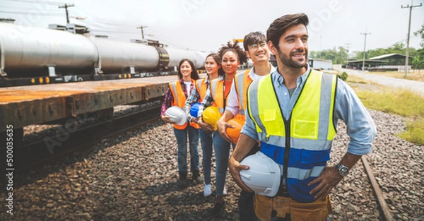 Fototapeta Team railway engineer holding helmet standing in row on site work.