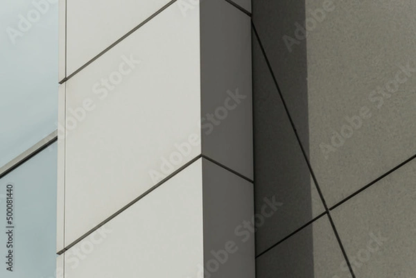 Fototapeta Geometric colored building facade elements with planes, lines and corners with light flare and reflections for an abstract background and texture of white, blue, gray colors. Place for text