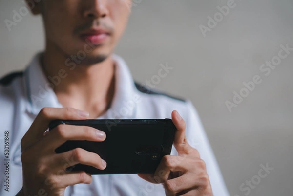 Fototapeta young man working on a horizontal phone with two hands.