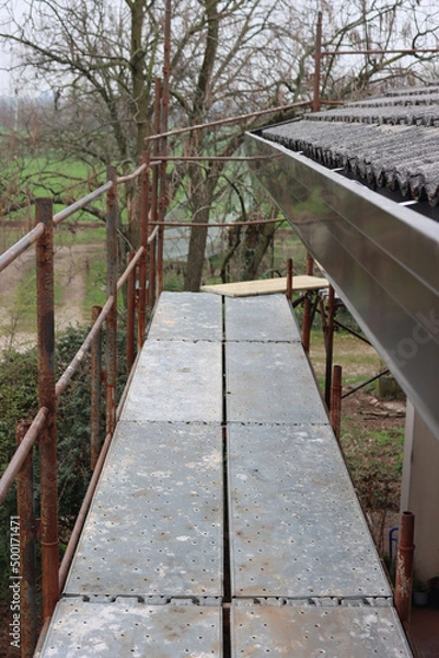 Fototapeta Detail of a scaffolding at a residential building for to replace tiles and gutter 