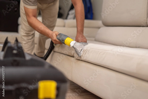 Fototapeta Cleaning a dirty sofa with a sofa washer