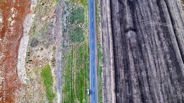Obraz drone shot of a car in the middle of a road 