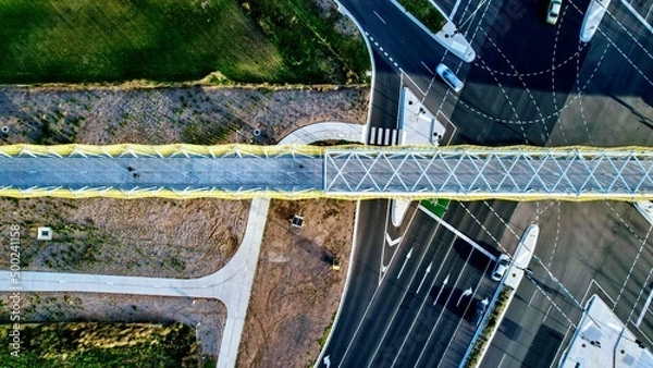 Obraz top down drone shot of a footbridge over a road