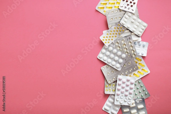 Fototapeta Blistry z lekarstwami i witaminami na różowym tle, leczenie nowotworów, rak piersi, amazonki