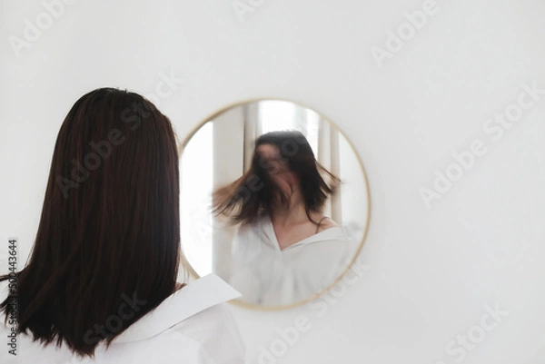 Fototapeta young woman looking in the mirror. Mental health problems in self-isolation at home. Depression, anxiety, phobia, suicide and mental health concept.