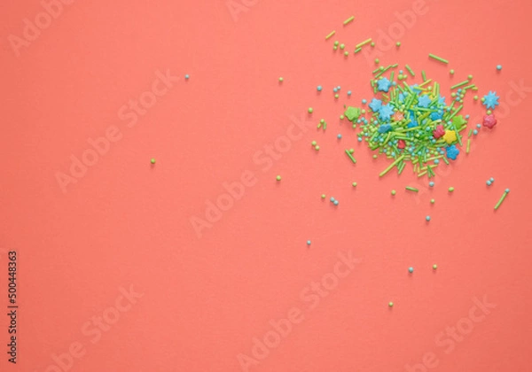 Obraz Multicolored icing sugar for confectionery on orange background top view.