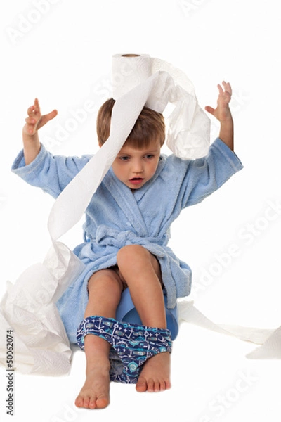 Fototapeta Little boy sitting on potty, rolls of toilet paper beside