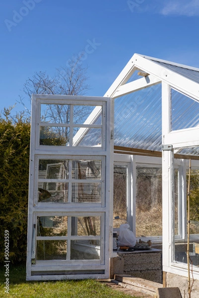 Fototapeta Greenhouse with open door in early spring. No people or plants growing