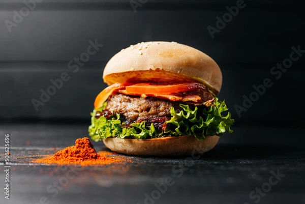 Fototapeta hamburger decorated
 paprika on a black wooden background composition