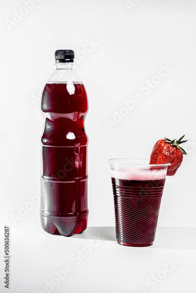 Fototapeta Strawberry lemonade in a bottle. Strawberry lemonade in a glass with ice and decorated with fresh strawberries on a white background 