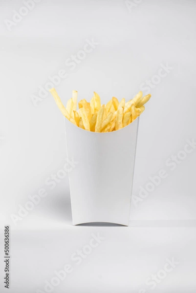 Fototapeta portion of french fries in a white box, fried potatoes in oil on a deep fryer