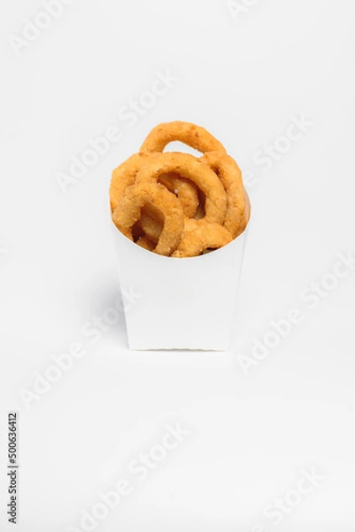 Fototapeta Rings of fried onions in batter lie in a box on a white background