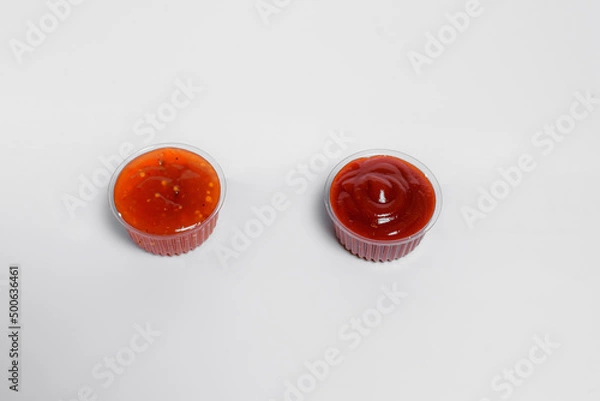 Fototapeta Ketchup and sauce in transparent boxes stands on a white background