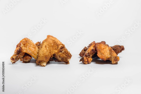 Fototapeta fried chicken wings in oil and breadcrumbs lie on a white background for three pieces