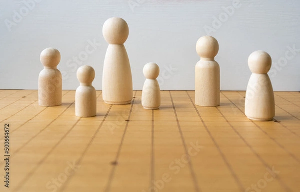 Fototapeta Wooden Figure of Various Size Placing on Chess Board Representing DIversity of People and Family