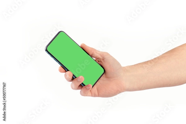Fototapeta Male hand holding smartphone with green screen, isolate.