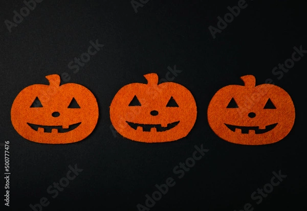Fototapeta Composition of figures of orange pumpkins and bats on a black background. DIY Halloween decor.Holiday card.Halloween holiday concept.Copy space.Top view.Pattern