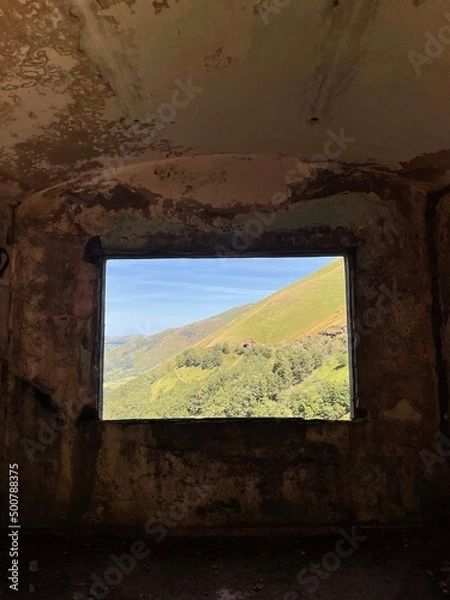 Obraz view of the spring valley through the abandoned building