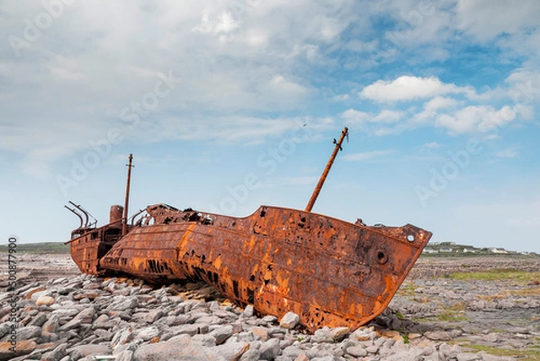 Fototapeta Plassey shipwreck on shore of Inisheer island. Aran islands, county Galway, Ireland. Rough stone coast and blue cloudy sky. Popular tourist landmark and attraction. Irish landscape