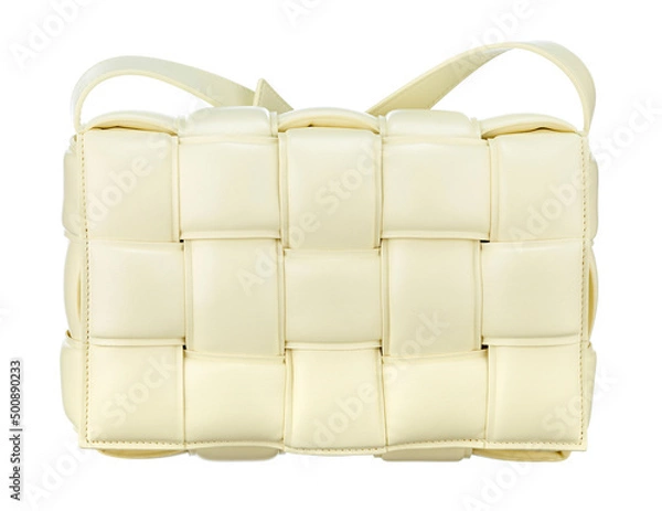 Fototapeta Magnificent bag made of cream-colored braided leather, with a strap-harness for carrying on the shoulder, isolated on a white background. Front view. Expensive women's accessories.