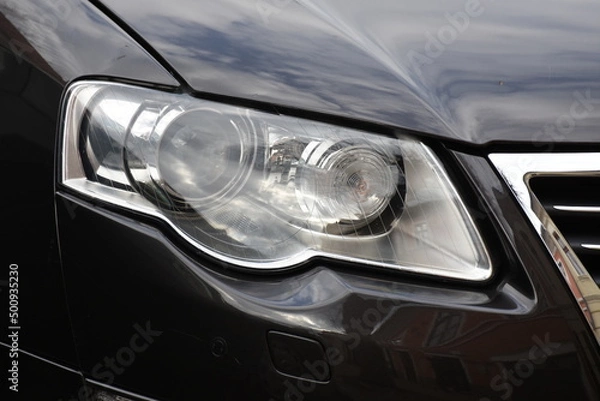 Obraz Car's exterior details.Blue car - headlight on a black  car