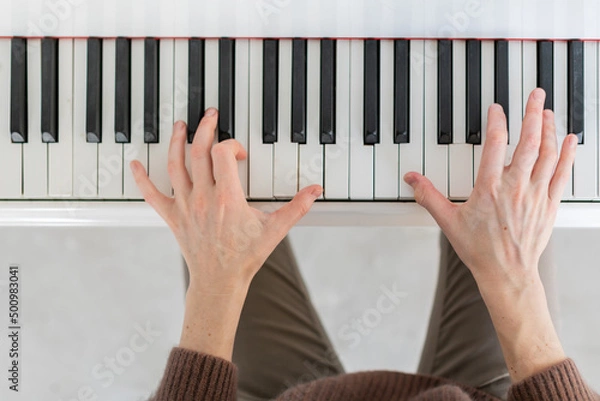 Fototapeta Closeup top view photo of grand piano with musican hands playing music