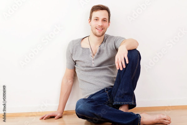 Obraz junger mann sitzt auf dem boden