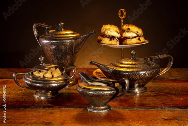 Obraz Still life with a vintage tea set and delicious scones with jam and cream, also served on vintage tableware.