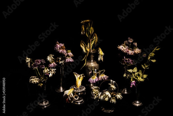 Obraz Still life of dead flowers in vintage vases, two weeks after their prime.  Faded colour on a black background.