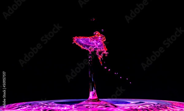 Obraz As red water was dropped into blue water, they mixed and splashed to create a shape that looks like a purple bird, or angel, hovering around a light.