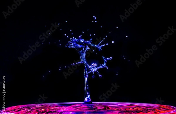 Obraz A blue water droplet splashing into red water, creating a beautiful alien shape.