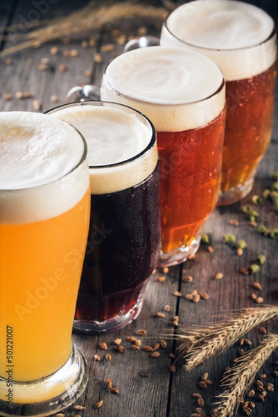 Obraz Variety of craft beer on a wooden table. Tasting set of different types of beer
