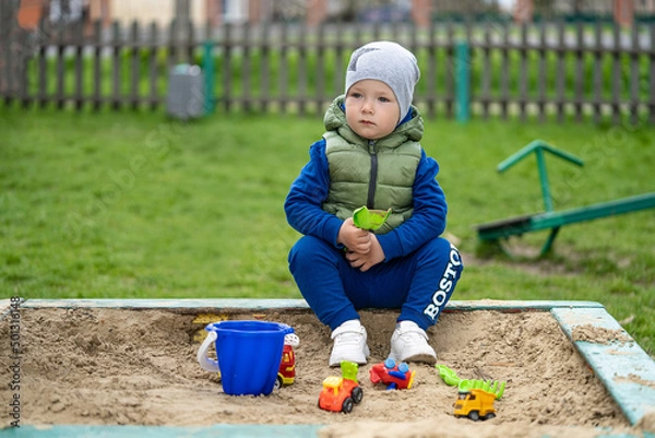 Fototapeta portrait of a 2 year old boy. Played in the playground in the sand on the street.