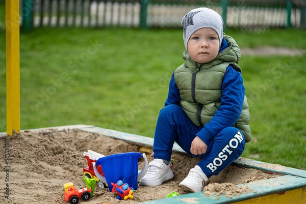 Fototapeta portrait of a 2 year old boy. Played in the playground in the sand on the street.