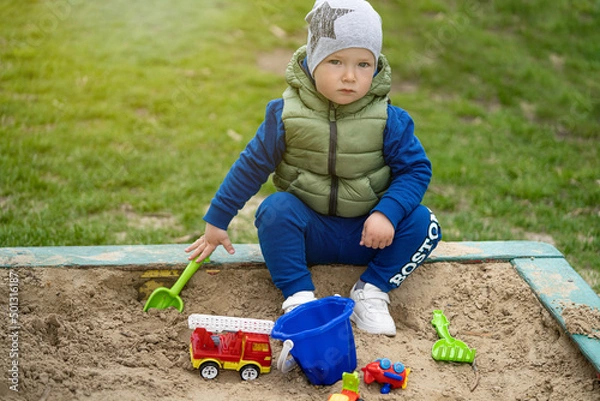 Fototapeta portrait of a 2 year old boy. Played in the playground in the sand on the street.