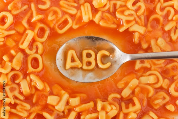 Fototapeta Pasta shaped ABC letters in tomato sauce on a spoon