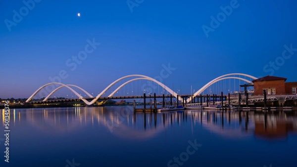 Fototapeta Waning Moon Over the Frederick Douglas Bridge and Anacostia River at Dawn on a Spring Morning