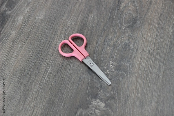Fototapeta scissors on the wooden floor. Top view, flat lay composition