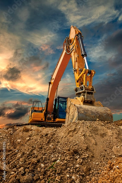 Fototapeta Crawler excavator during earthmoving works on construction site at sunset