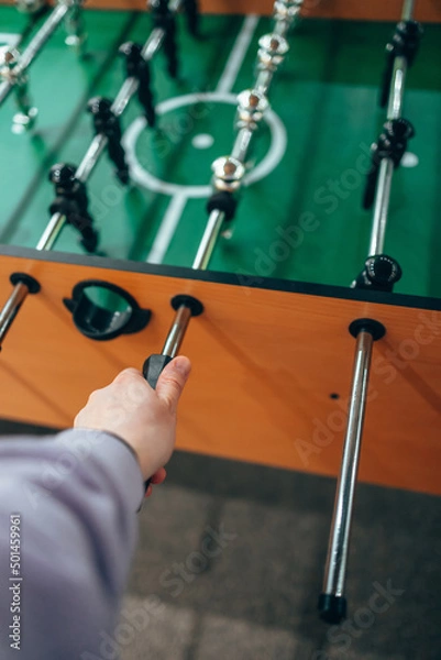 Fototapeta Table football, kicker. A woman's hand holds the control knob.