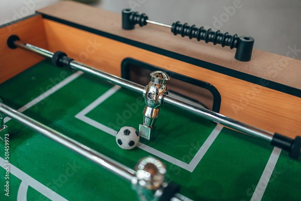 Fototapeta Table football. Kicker. A shiny figure from table football. Green field. The goalkeeper defends his goal.