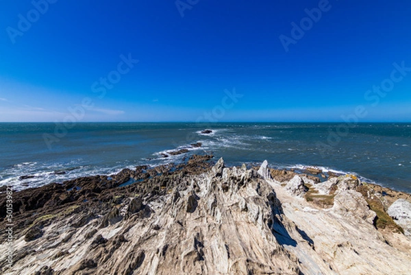 Obraz Across the rocks at Morte Point, looking out towards the sea.  A crystal clear blue sky on a bright April day.