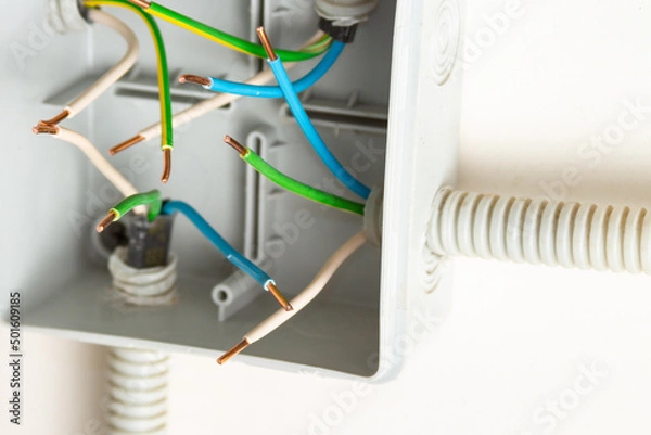 Fototapeta Bare contacts of electrical wires in a junction box on the wall