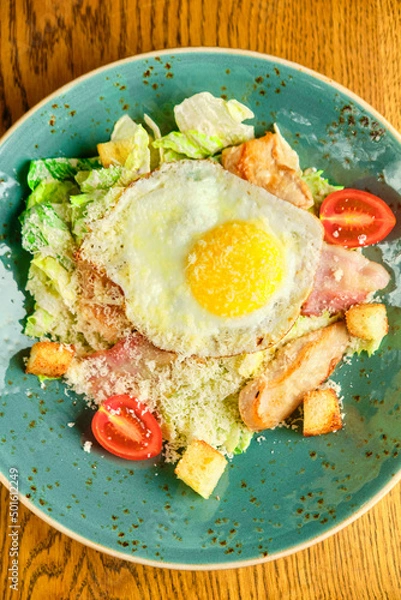 Obraz Caesar salad with large fried eggs