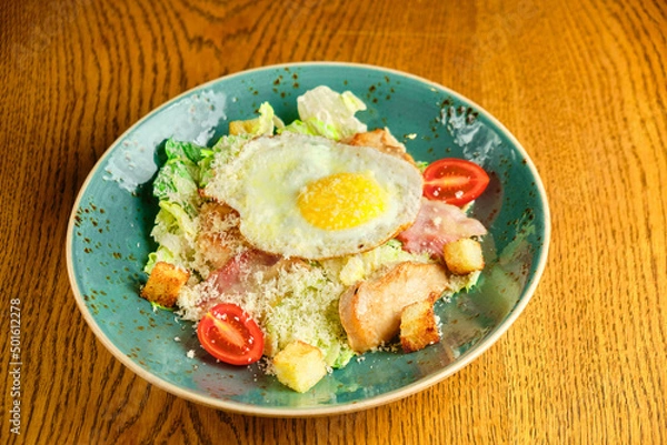Obraz Caesar salad with large fried eggs
