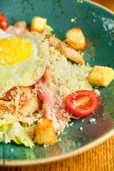 Obraz Caesar salad with large fried eggs
