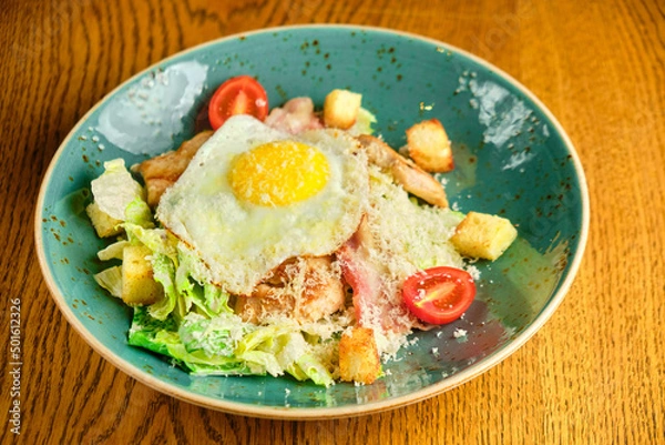 Obraz Caesar salad with large fried eggs
